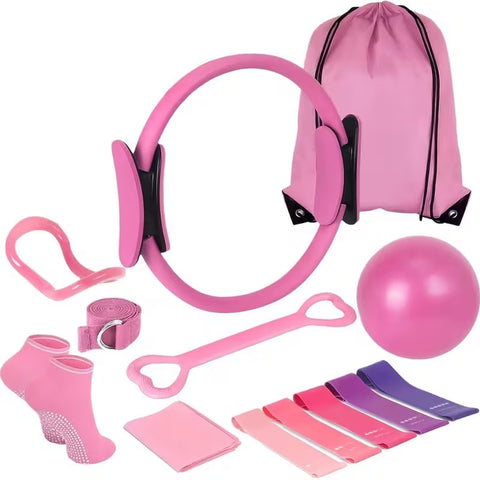 Pink movement kit arranged on white with a resistance ring, ball, five loop bands, two pink loop pieces, a D-ring strap, grip-dot socks, a folded pink item and a drawstring bag.